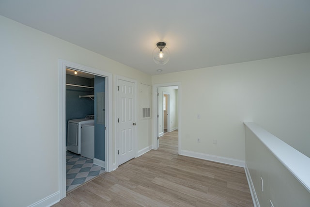 interior space featuring washer and dryer, baseboards, visible vents, and light wood finished floors