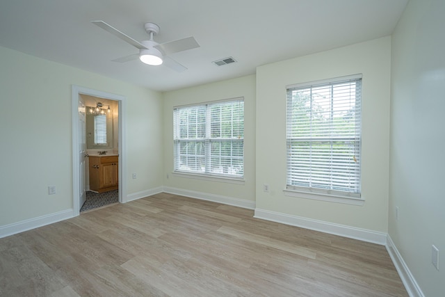 empty room with visible vents, a wealth of natural light, and light wood-type flooring