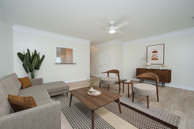living area with crown molding, ceiling fan, baseboards, and light wood-type flooring