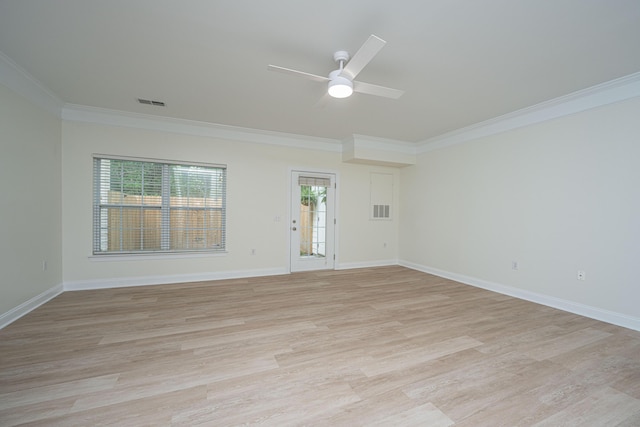 empty room with a ceiling fan, baseboards, light wood-type flooring, visible vents, and ornamental molding
