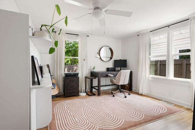 office featuring wood finished floors, ceiling fan, and baseboards