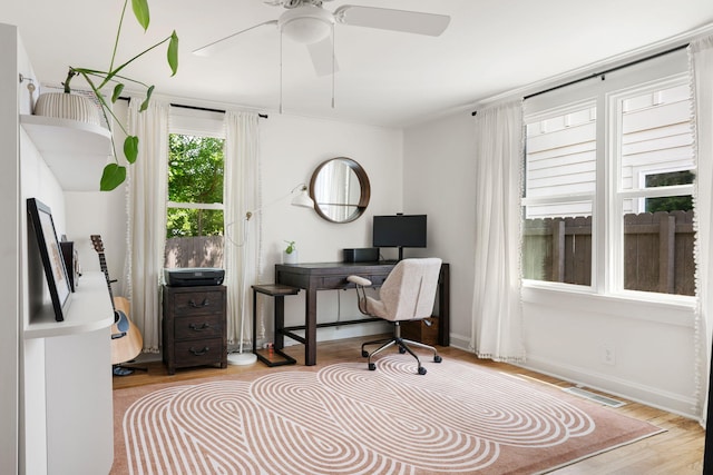 home office featuring wood finished floors, ceiling fan, and baseboards