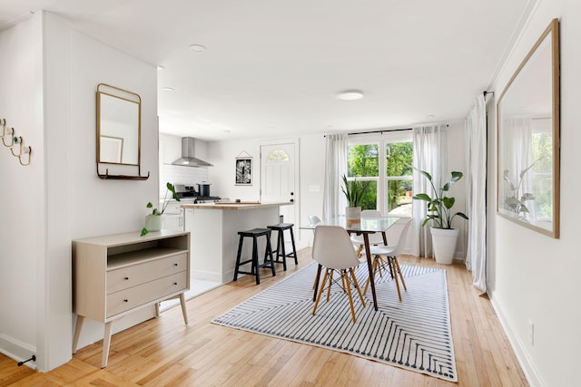 dining space with light wood-style floors and baseboards