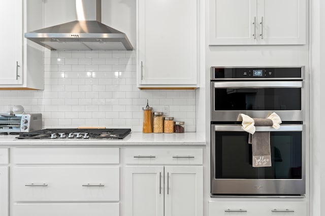 kitchen with white cabinetry, wall chimney exhaust hood, and appliances with stainless steel finishes