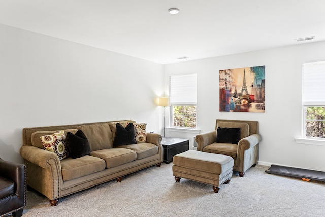 living area featuring carpet flooring, a healthy amount of sunlight, and visible vents