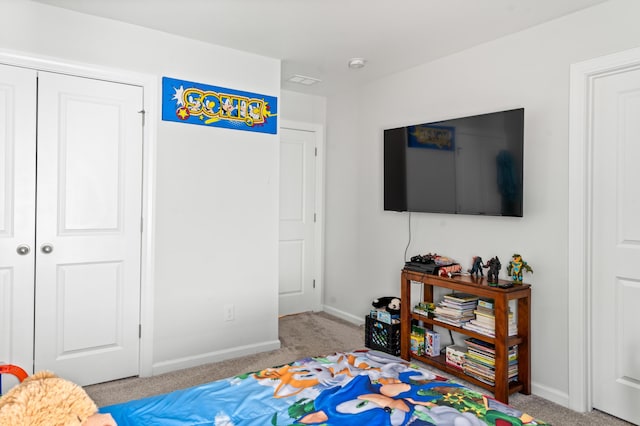 carpeted bedroom featuring a closet and baseboards