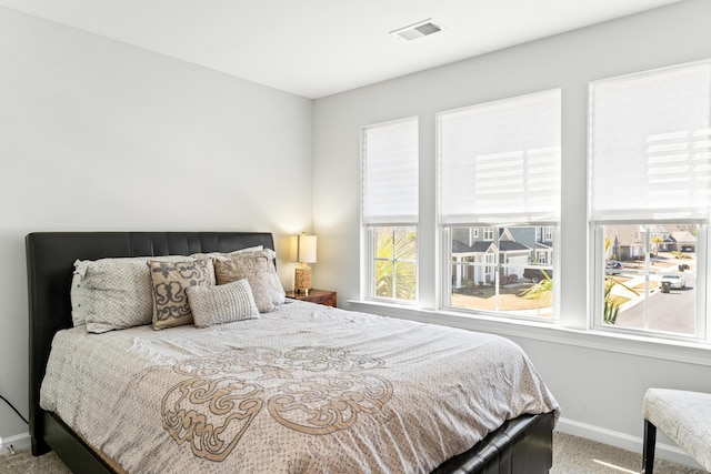 carpeted bedroom featuring visible vents and baseboards