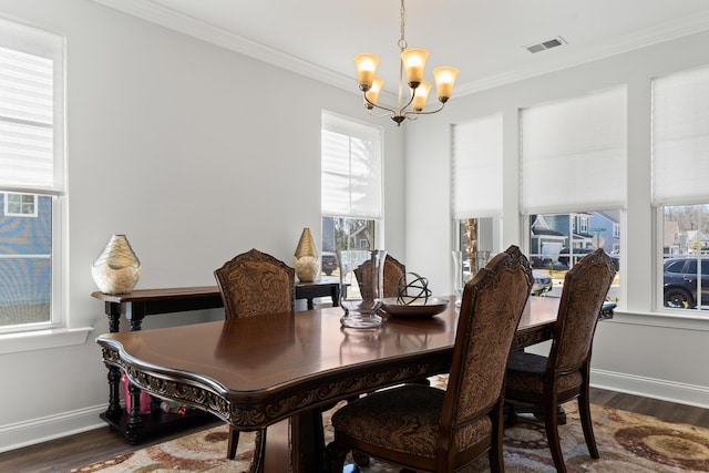 dining space featuring baseboards, visible vents, ornamental molding, dark wood-type flooring, and a chandelier