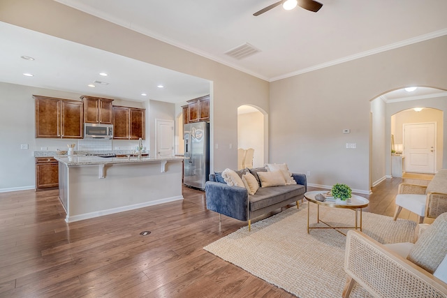 living room with ceiling fan, dark hardwood / wood-style flooring, and crown molding