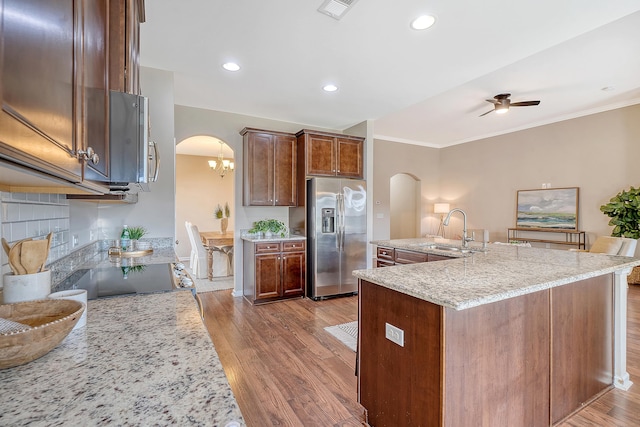 kitchen featuring crown molding, sink, appliances with stainless steel finishes, light hardwood / wood-style floors, and light stone counters