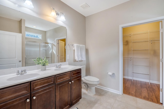 bathroom featuring hardwood / wood-style floors, vanity, toilet, and walk in shower