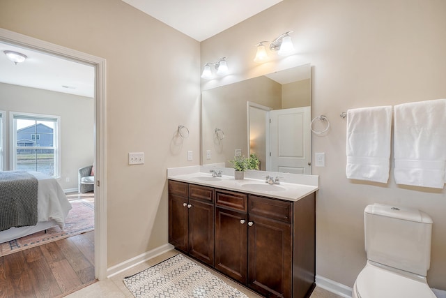 bathroom with hardwood / wood-style floors, vanity, and toilet