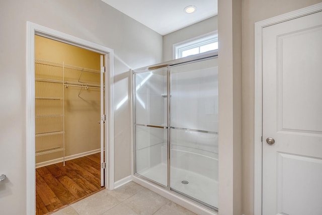 bathroom featuring hardwood / wood-style flooring and a shower with door