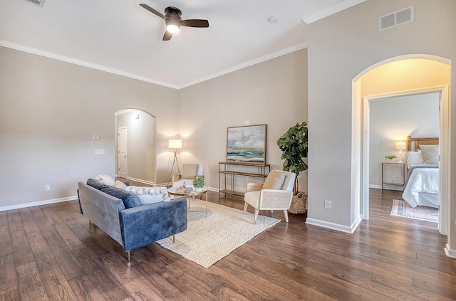 living room with ornamental molding, ceiling fan, and dark wood-type flooring