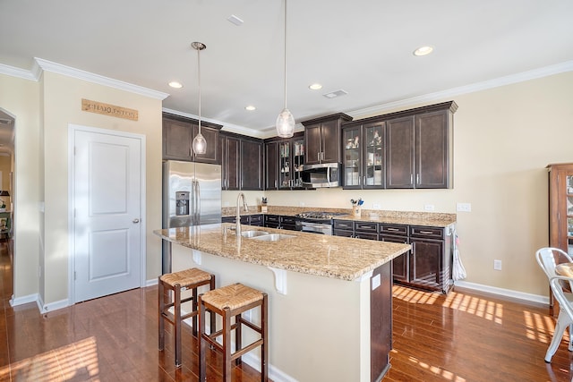 kitchen featuring dark hardwood / wood-style floors, sink, a center island with sink, appliances with stainless steel finishes, and dark brown cabinetry