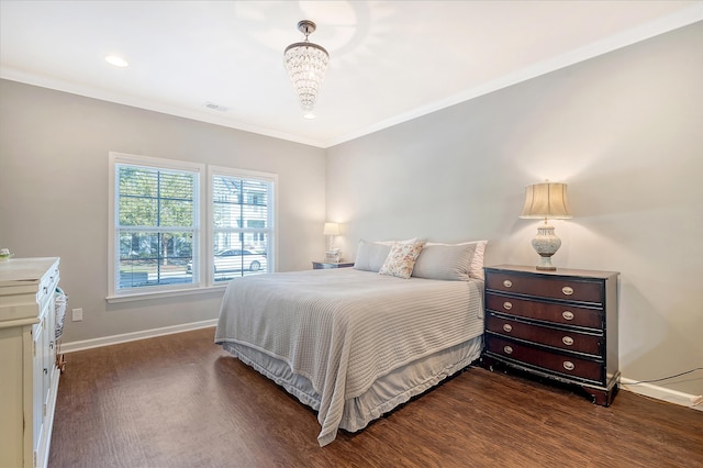 bedroom with dark hardwood / wood-style floors, ornamental molding, and a chandelier