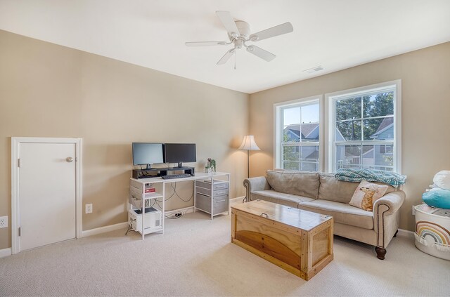 carpeted living room with ceiling fan