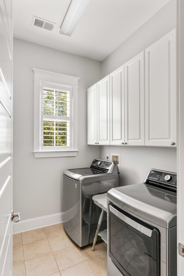 1527 Wando View St, Charleston, SC 29492 - laundry area with cabinet space, independent washer and dryer, baseboards, and light tile patterned floors