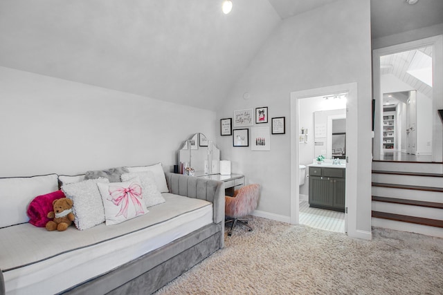carpeted bedroom featuring baseboards, ensuite bath, and vaulted ceiling