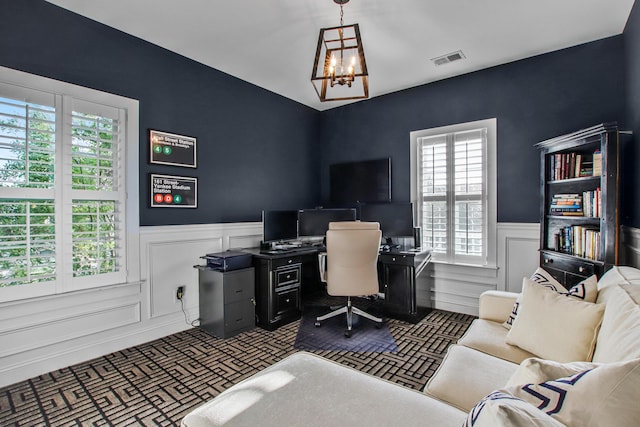 office area with wainscoting, brick patterned floor, a chandelier, and visible vents
