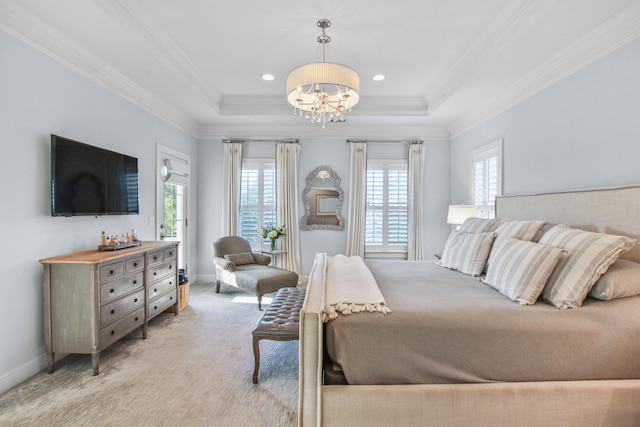 bedroom with multiple windows, a tray ceiling, and a notable chandelier