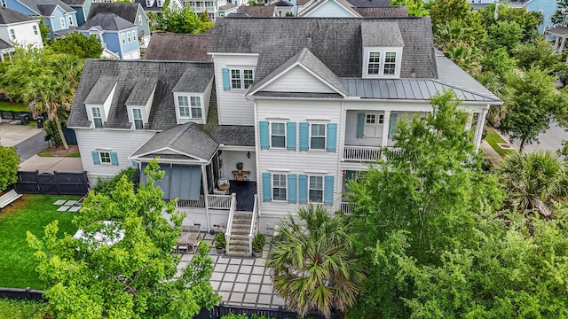view of front of home with a residential view, roof with shingles, stairway, a standing seam roof, and metal roof