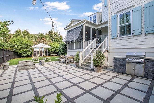 view of patio featuring grilling area, outdoor dining area, a sunroom, fence, and an outdoor fire pit