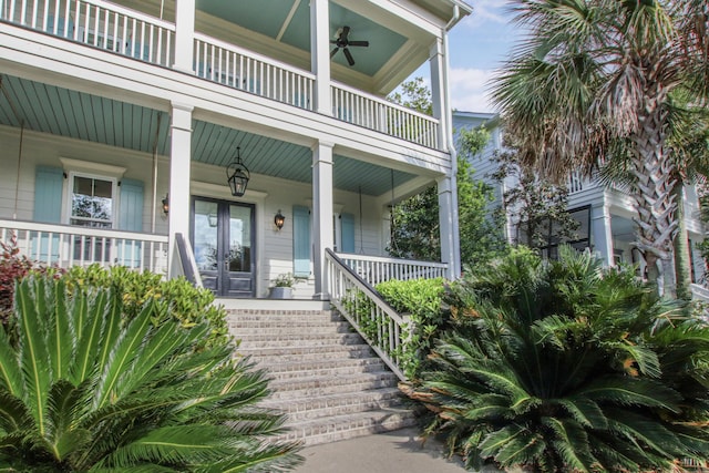 view of exterior entry featuring a porch, ceiling fan, and a balcony