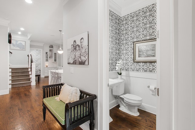 bathroom with ornamental molding, wood finished floors, toilet, and a wainscoted wall