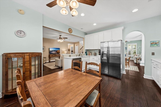 dining room featuring ceiling fan, sink, and dark wood-type flooring