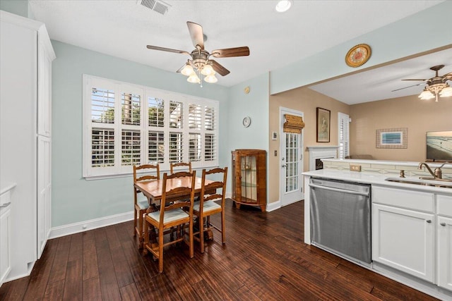 dining area featuring ceiling fan, sink, and dark wood-type flooring