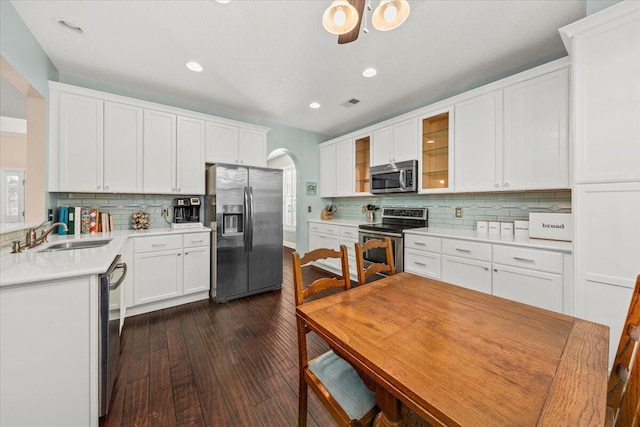 kitchen with backsplash, dark wood-type flooring, sink, appliances with stainless steel finishes, and white cabinetry