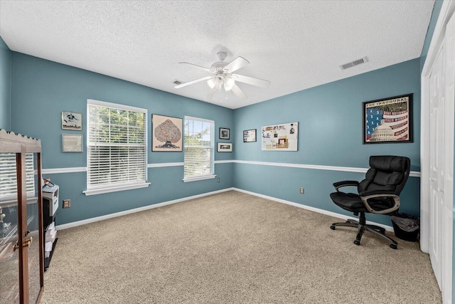 interior space featuring carpet flooring, a textured ceiling, and ceiling fan