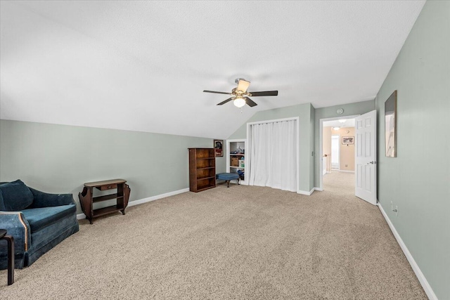 sitting room with light carpet, a textured ceiling, vaulted ceiling, and ceiling fan