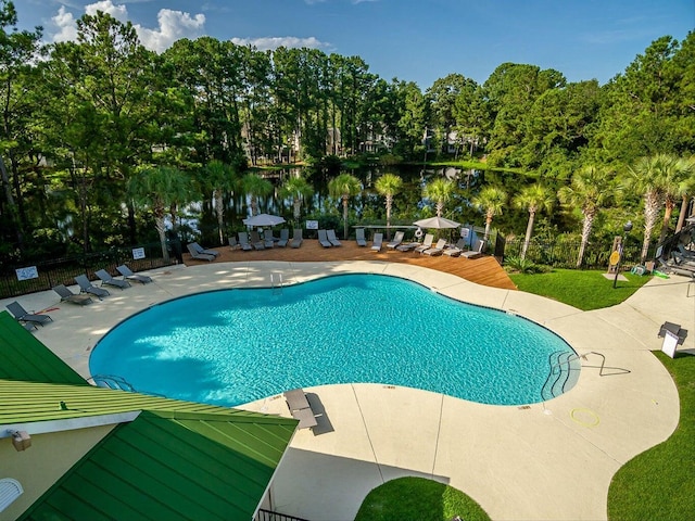 view of swimming pool featuring a patio and a water view