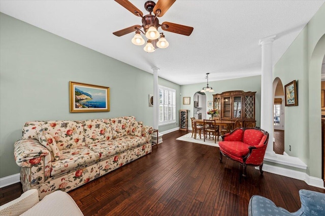 living room featuring hardwood / wood-style floors, ceiling fan, ornate columns, and a textured ceiling