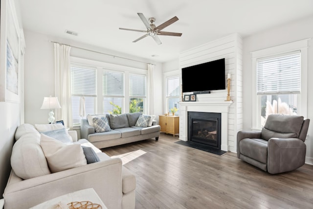 living room with hardwood / wood-style floors, plenty of natural light, a large fireplace, and ceiling fan