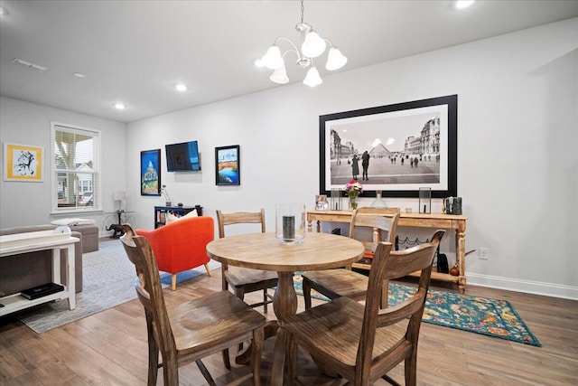 dining space with an inviting chandelier and hardwood / wood-style floors