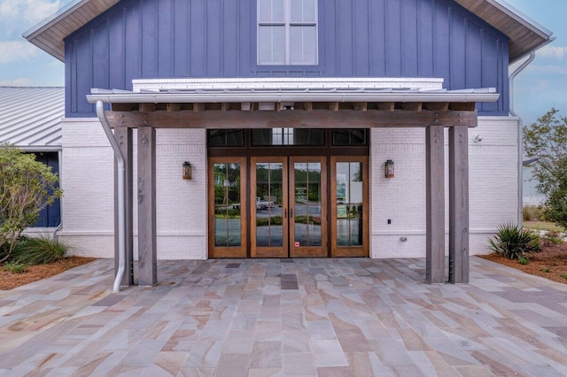 view of exterior entry featuring french doors and a patio