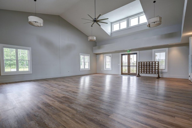 unfurnished living room with dark wood-type flooring, ceiling fan, high vaulted ceiling, and french doors