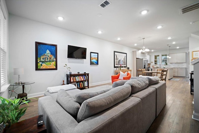 living room with hardwood / wood-style flooring and a chandelier