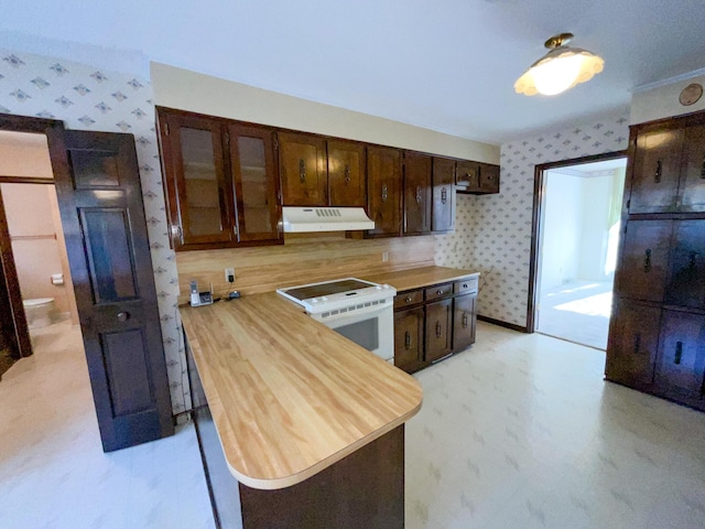 kitchen with white range with electric stovetop, wooden counters, dark brown cabinets, under cabinet range hood, and wallpapered walls