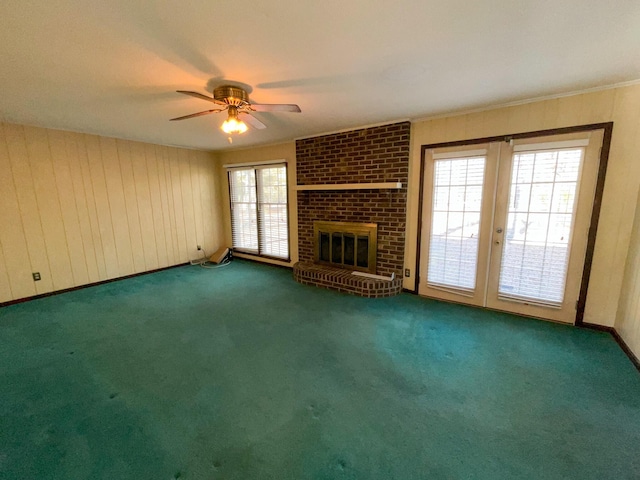 unfurnished living room featuring ornamental molding, a brick fireplace, carpet flooring, and a ceiling fan