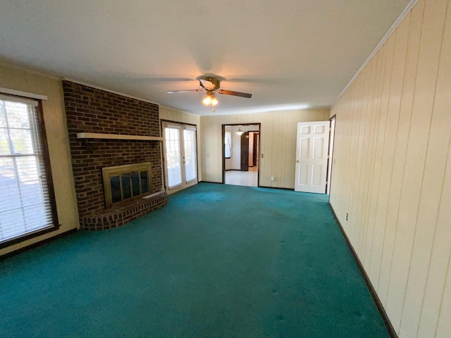 unfurnished living room featuring carpet floors, ceiling fan, a fireplace, and ornamental molding