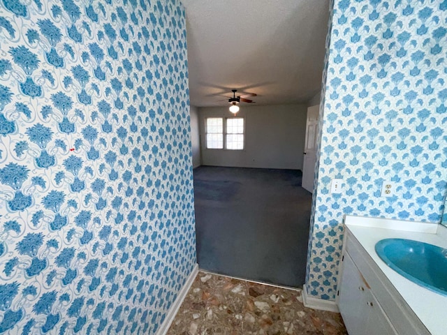 bathroom featuring ceiling fan, a textured ceiling, and vanity