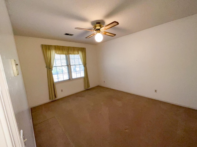 spare room with ceiling fan, light carpet, and visible vents