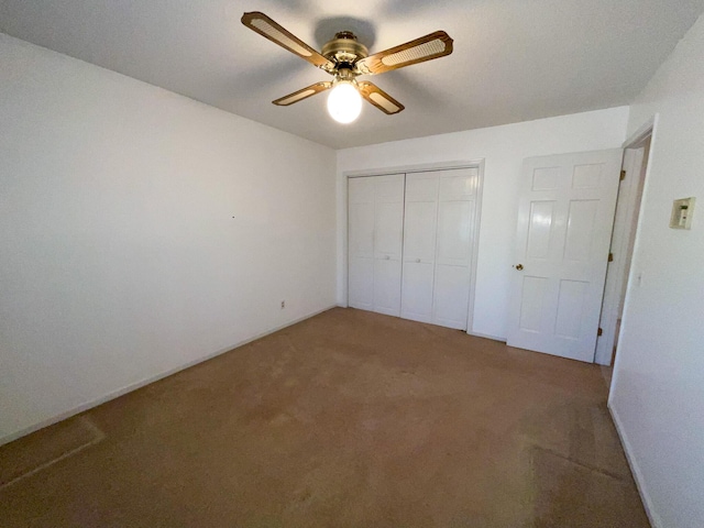 unfurnished bedroom featuring carpet, ceiling fan, and a closet