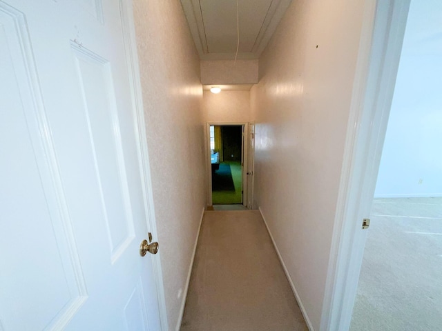 hallway featuring attic access and baseboards