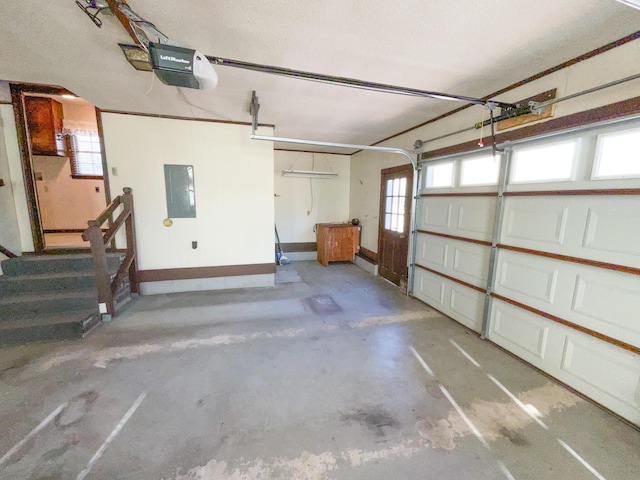 garage featuring electric panel, baseboards, and a garage door opener