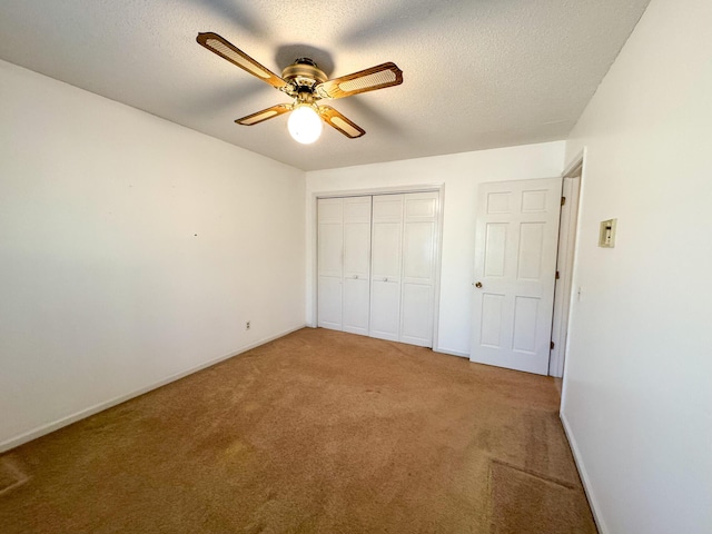 unfurnished bedroom featuring a textured ceiling, a ceiling fan, baseboards, a closet, and carpet